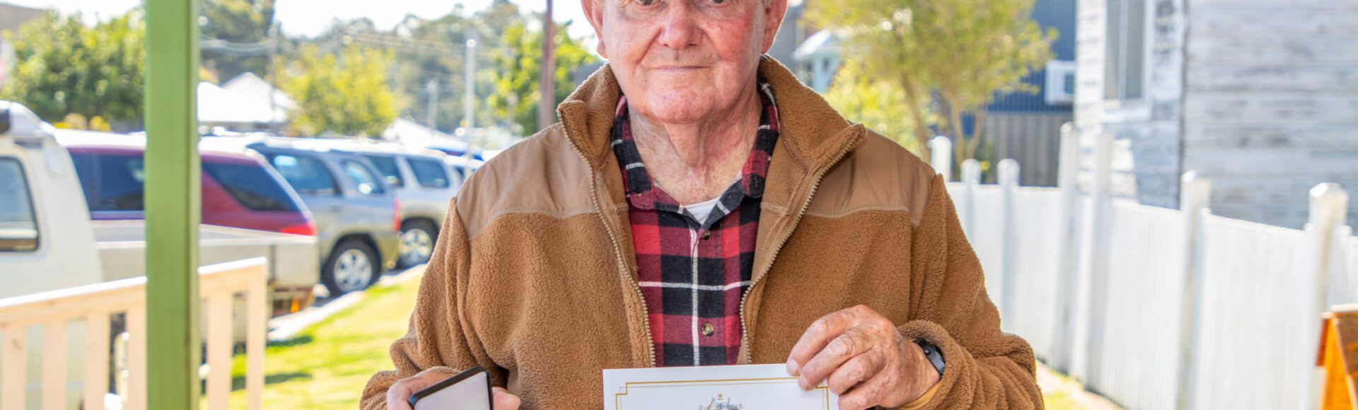 Man holding war medal and certificate