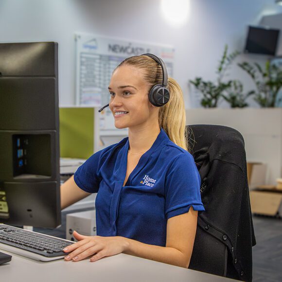 Person with headphones looking at a monitor.