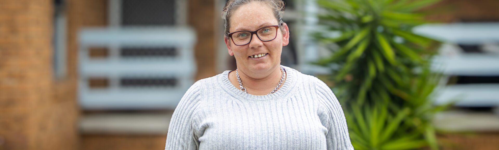 Woman standing in front of a brick house