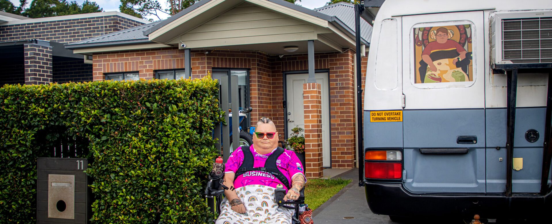 Woman in a wheelchair outside her home