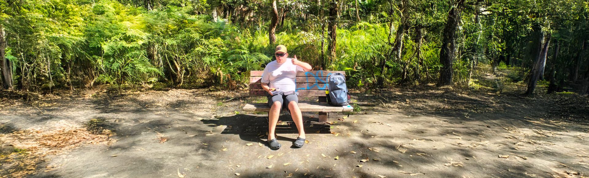 Young man sitting on a park bench in a forest