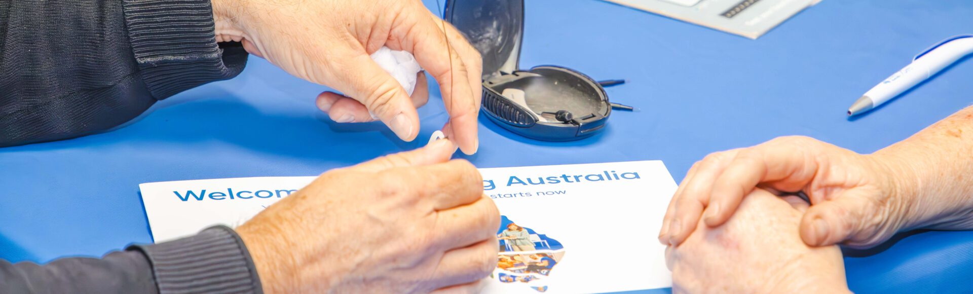 Close up of a person holding the components of their hearing aid