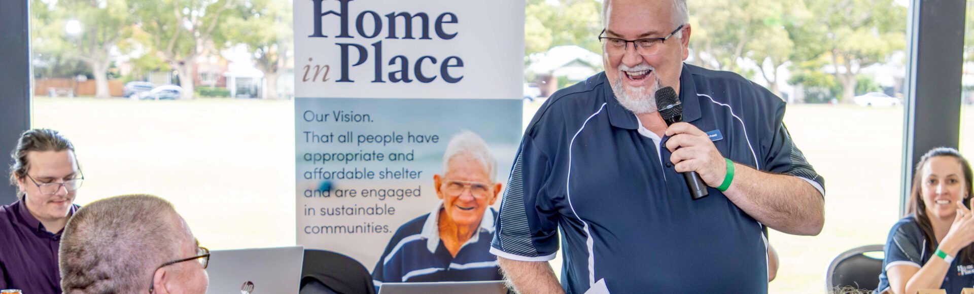 Smiling man talking on a microphone