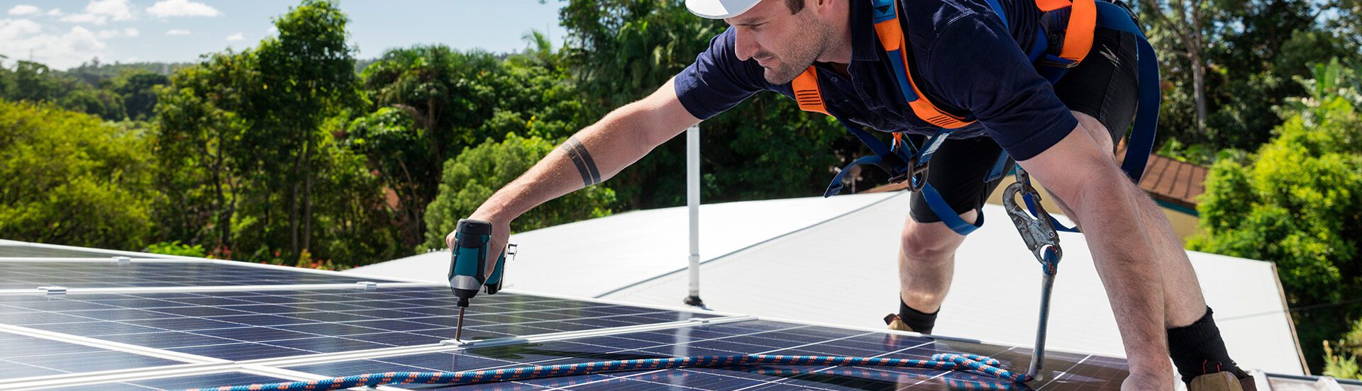 Man on a roof installing solar panels