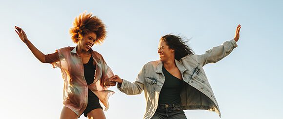 Two young women balancing on a seesaw
