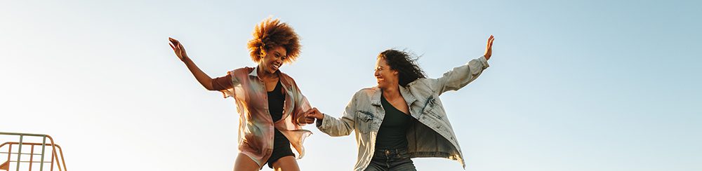 Two young women balancing on a seesaw