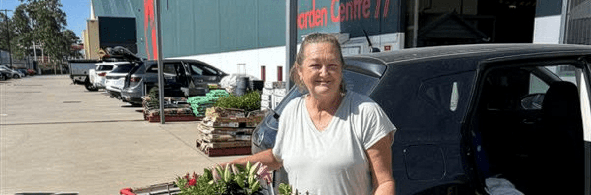 Woman with a trolley of plants in front of Bunnings