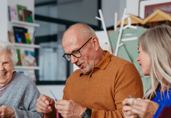 Group of people laughing and knitting