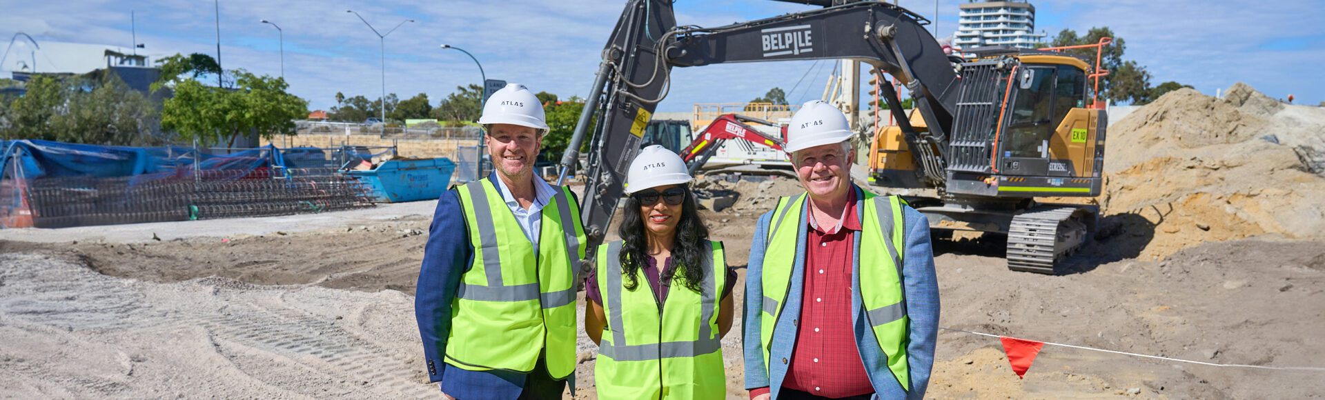 Three people in hard hats on a construction site