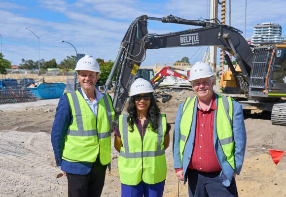 Three people in hard hats on a construction site