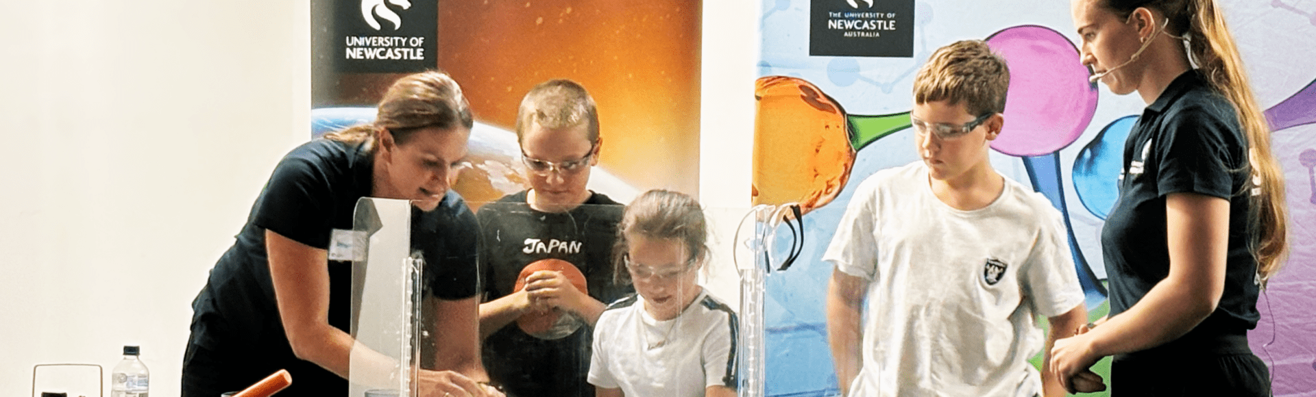 Group of people around a desk watching a science experiment