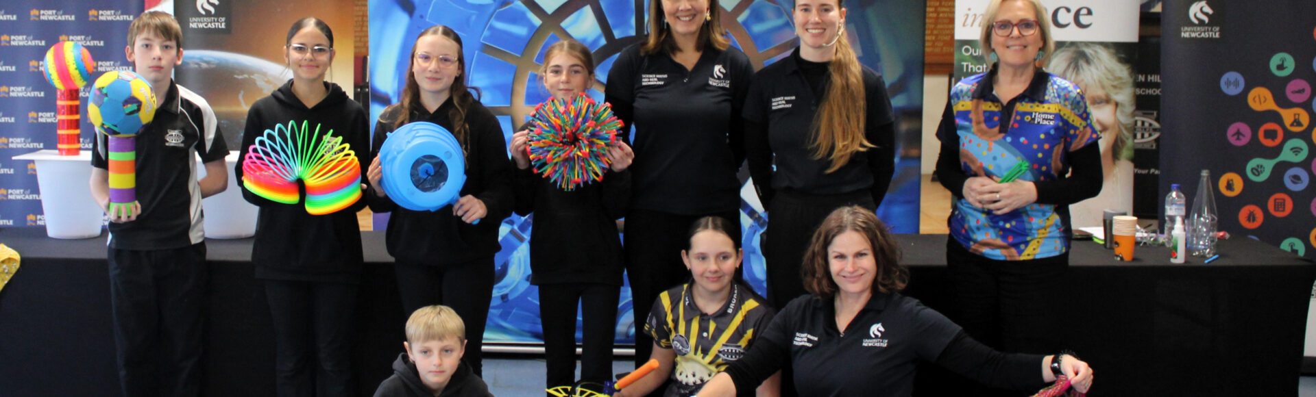 Michelle Faithfull and the University of Newcastle SMART team with students at the front of a classroom, holding science equipment during a Curious Minds STEM session.